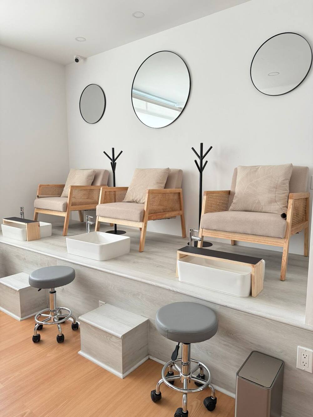 Área de pedicure spa de Aura Nails Salon con sillones de madera y tinas individuales